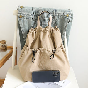 Lightweight drawstring bucket backpack in beige with top handles