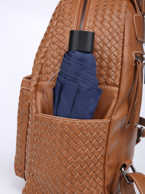 Brown woven handbag with a navy umbrella inside on a white background
