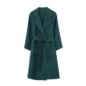 Green women's loose fit mid-length coat with a belt on a white background