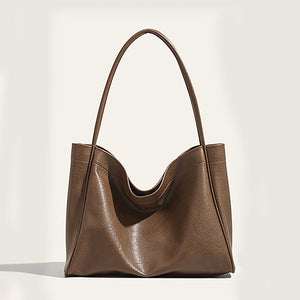 Brown leather handbag on a light beige background