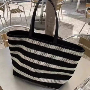 Black and white striped tote bag on a table outdoors