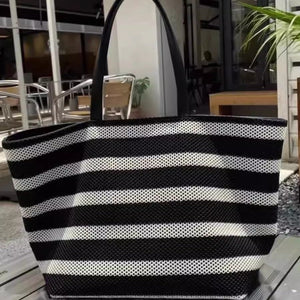 Black and white striped tote bag on a table with an indoor background