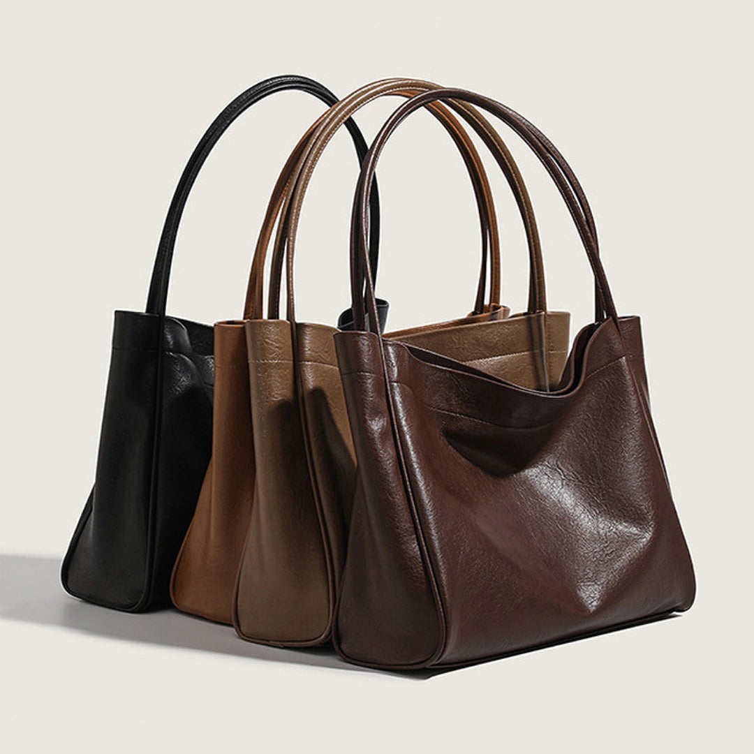 Three retro minimalist commuter tote bags in black, brown, and beige on a light background