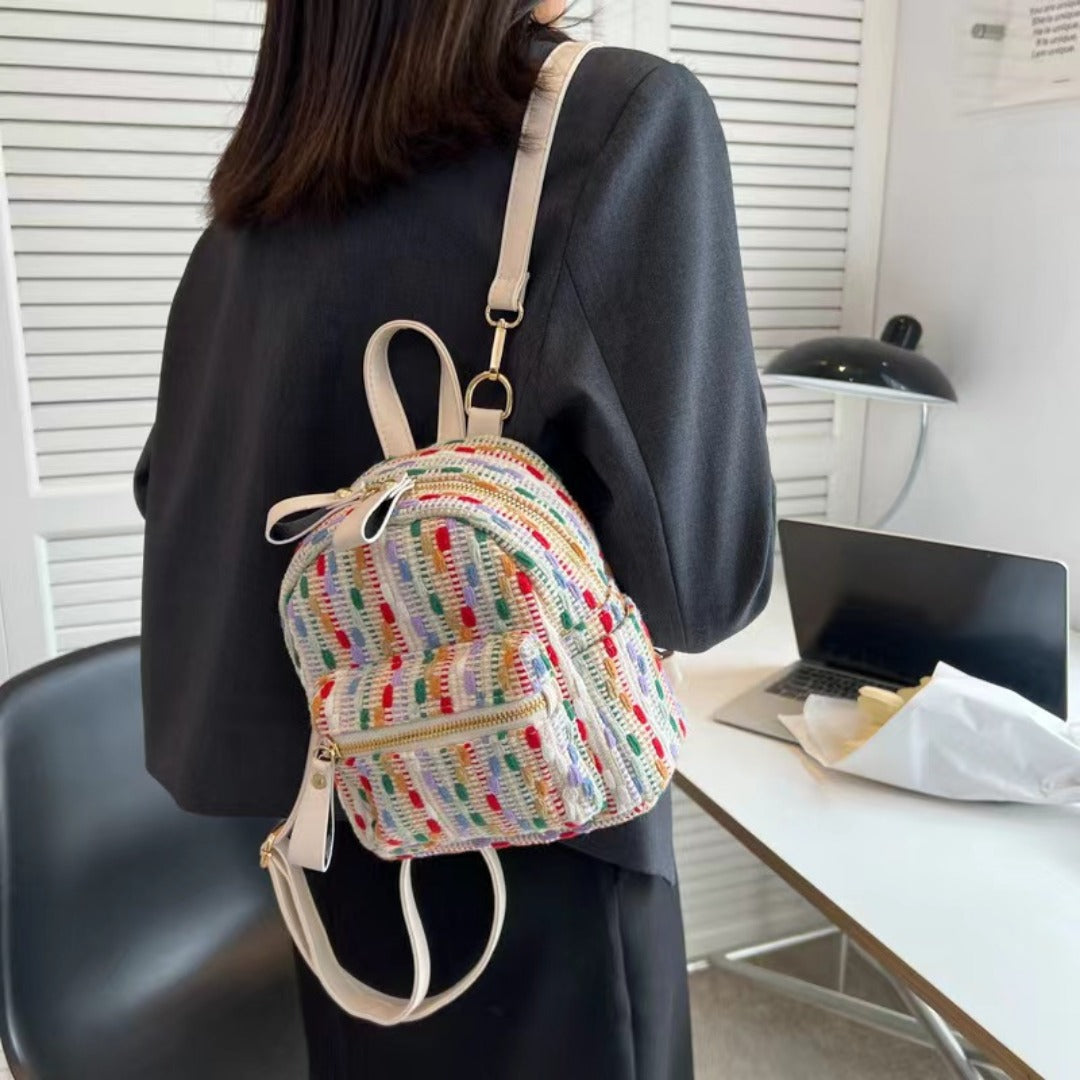 Person wearing a colorful mini backpack in an office setting