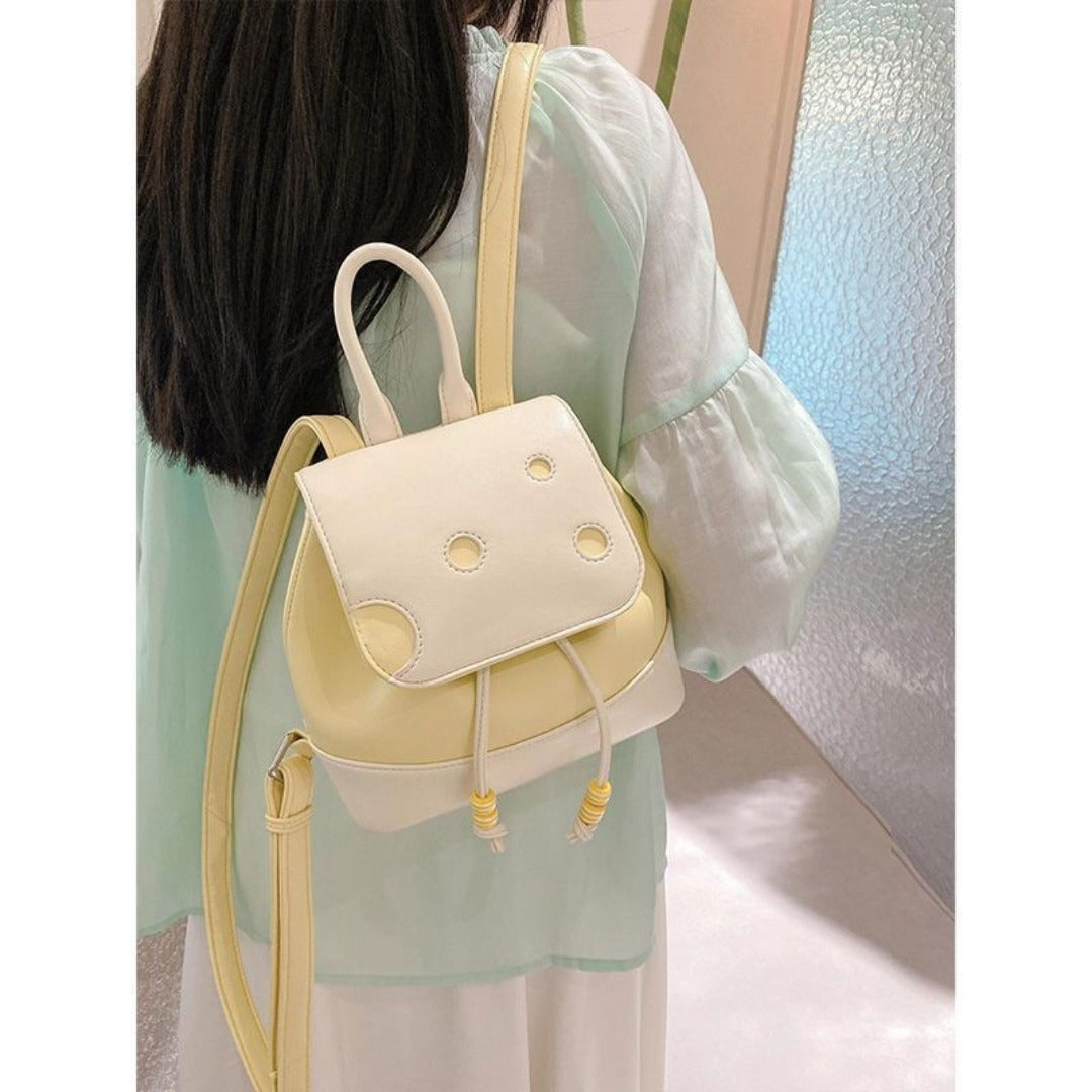 Person wearing a light-colored backpack with yellow accents