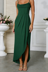 Green side slit halter maxi dress worn by a person in an elegant indoor setting with floral decorations.