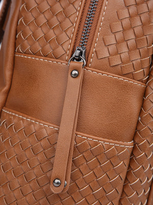 Close-up of a woven vegan leather backpack purse with a zipper and strap.