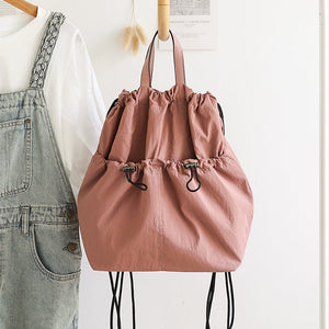 Pink drawstring bag on a stand with a white background