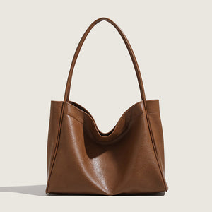 Brown leather handbag on a light beige background