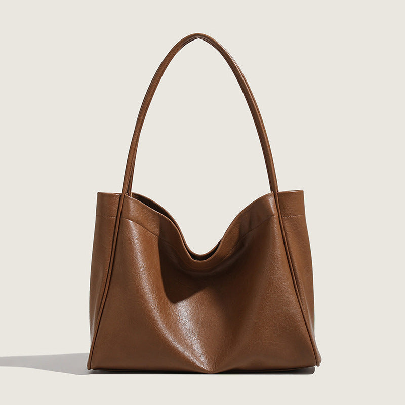 Brown leather handbag on a light beige background