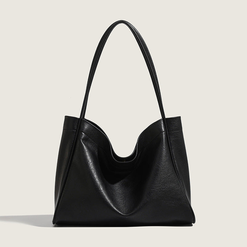 Black leather handbag on a light gray background