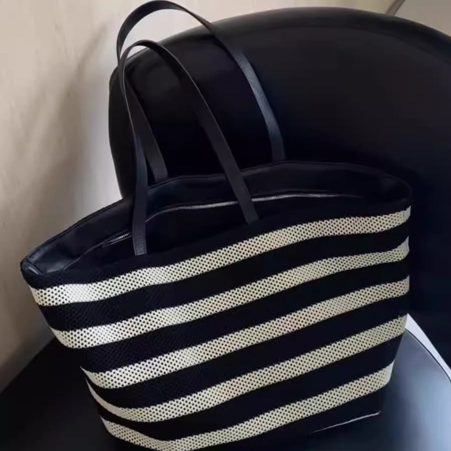 Black and white striped tote bag on a chair