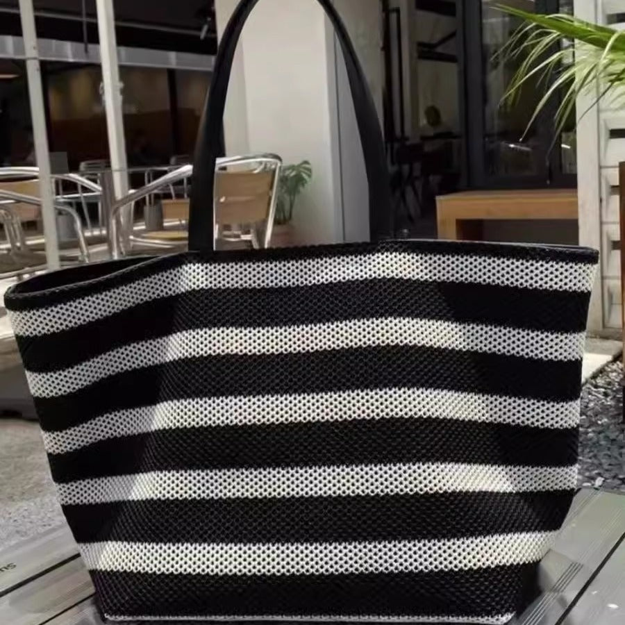 Black and white striped tote bag on a table with an indoor background