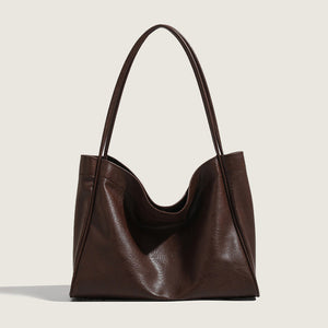 Brown leather handbag on a light beige background