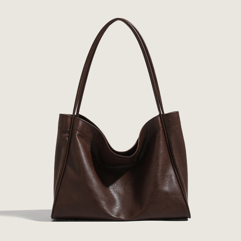 Brown leather handbag on a light beige background