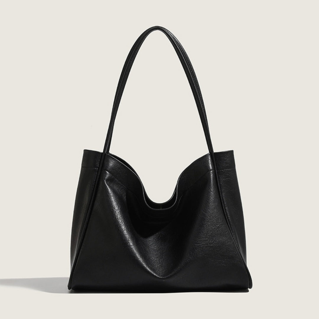 Black leather handbag on a light gray background