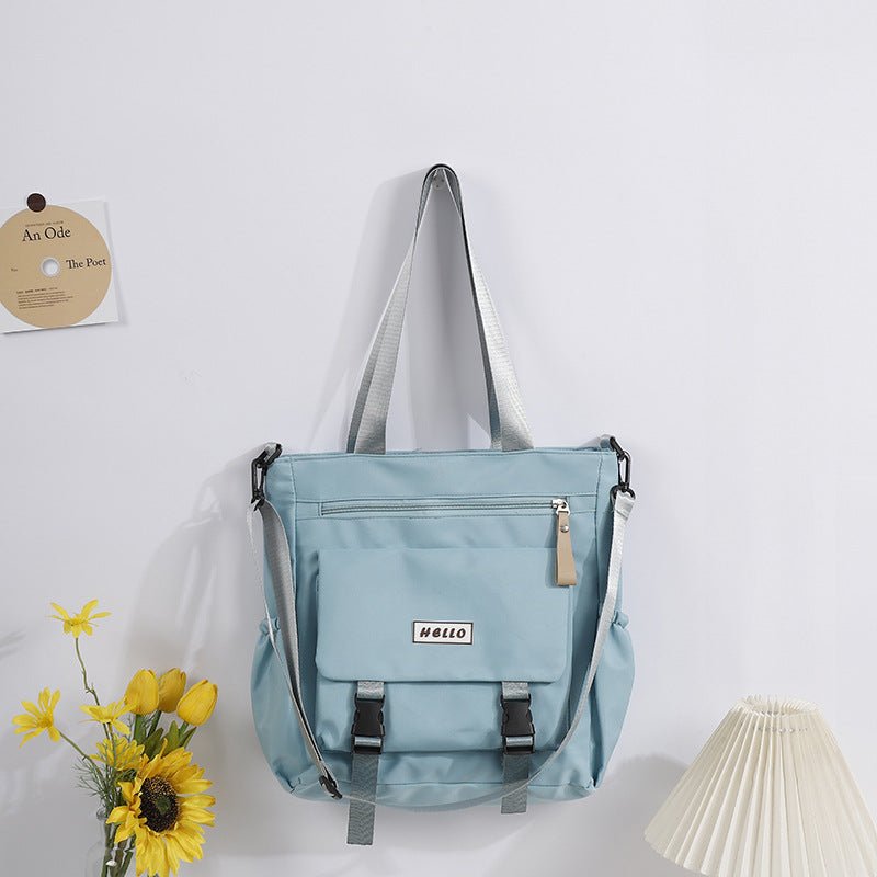 Light blue backpack with 'HELLO' label on a white background with yellow flowers and a lamp.
