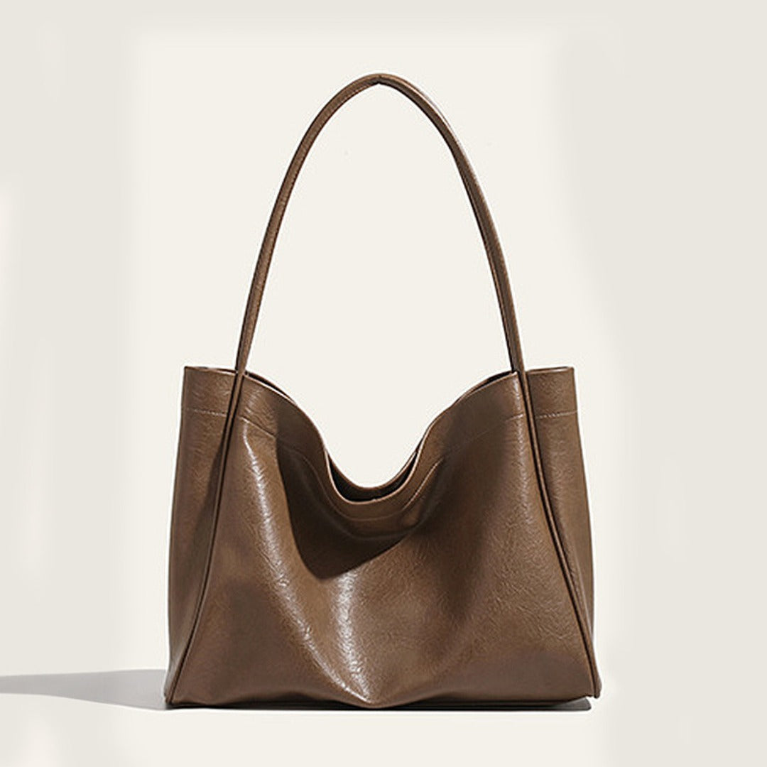 Brown leather handbag on a light beige background