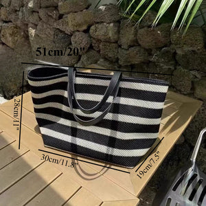 Black and white striped tote bag with measurements on a stone surface