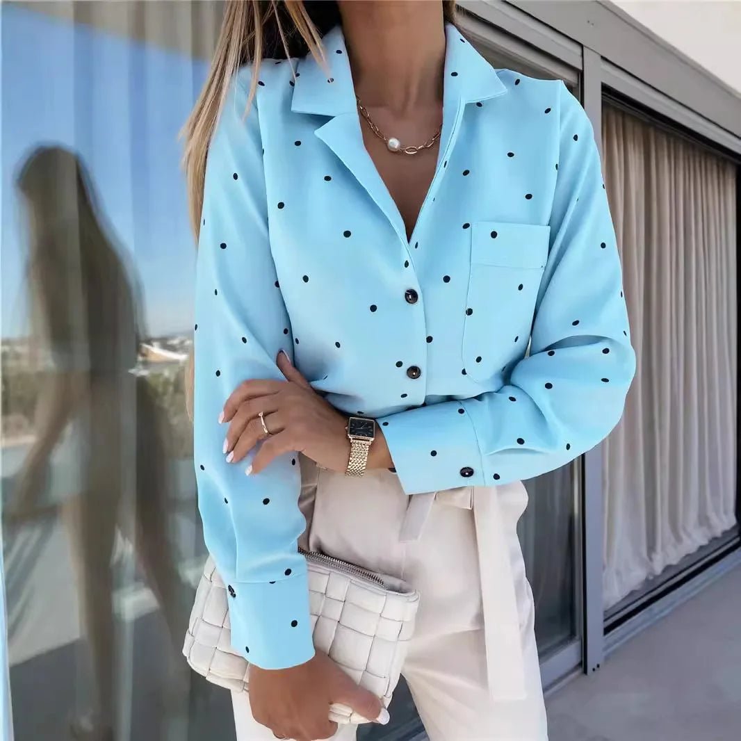 Person wearing a light blue polka dot shirt with a blurred background