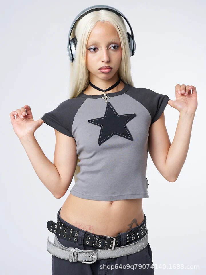Woman wearing a Y2K cropped t-shirt with a star design and black headphones on a white background